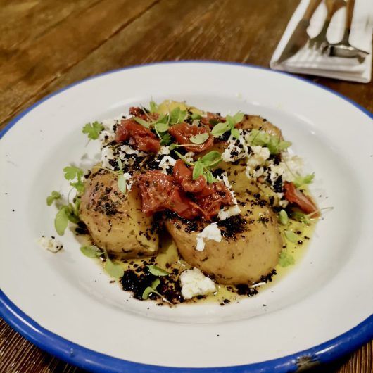 Patatas asadas a la mantequilla de hierbas Ricota , tomate seco,